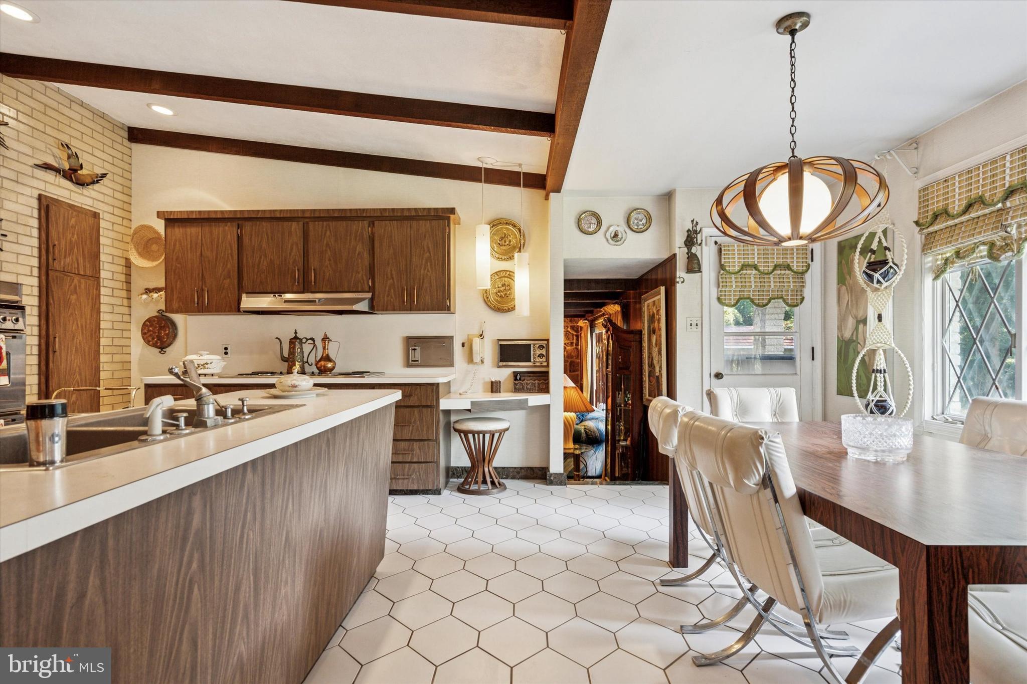 341 Cedar Road Elkins Park, PA 19027 - Photo 13 of 59 a kitchen with stainless steel appliances a stove top oven a sink a dining table and chairs with wooden floor