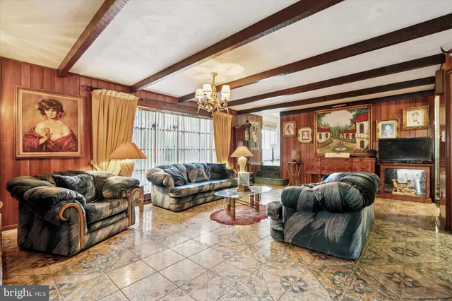 a living room with furniture a fireplace and a floor to ceiling window