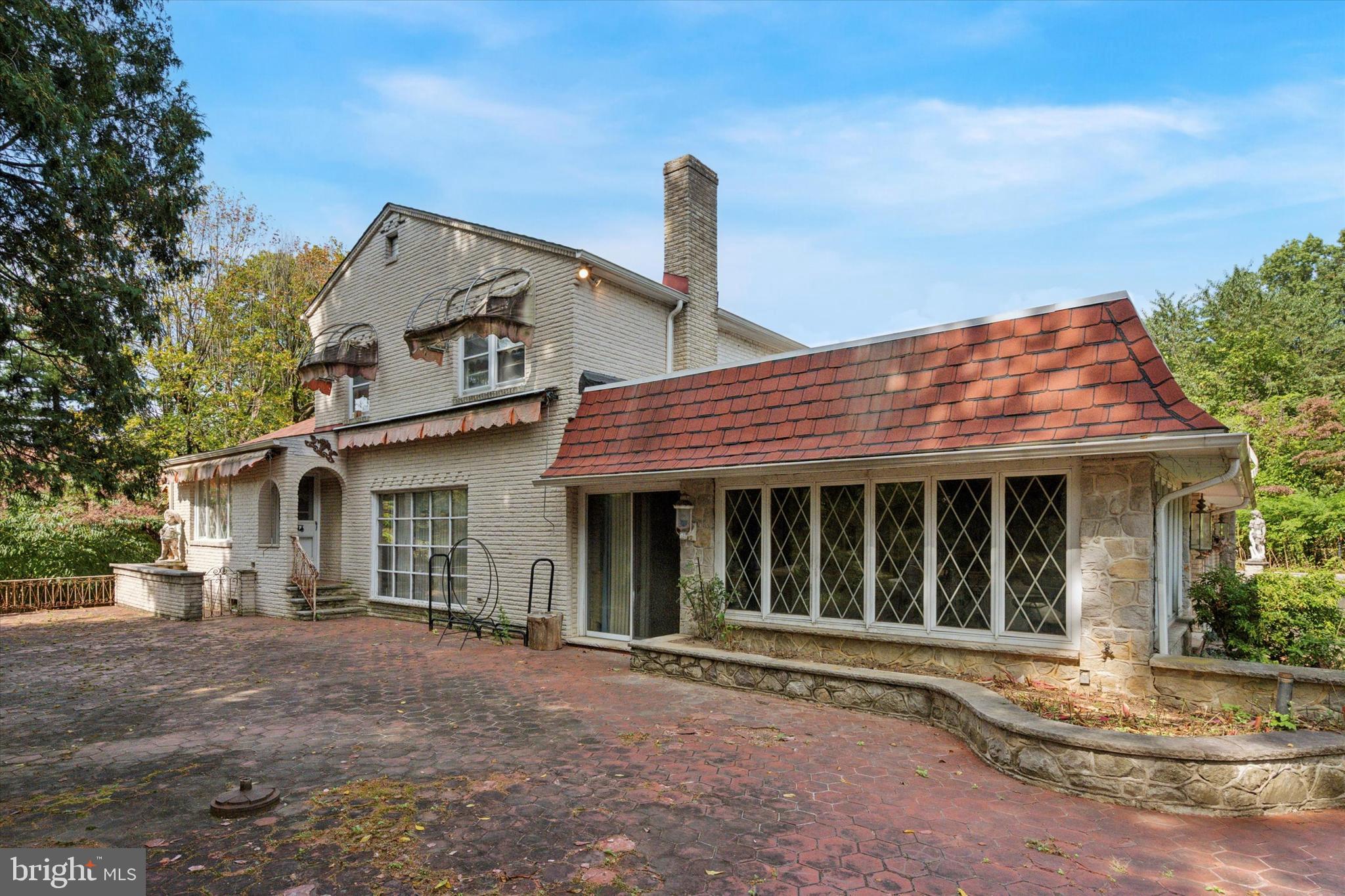 341 Cedar Road Elkins Park, PA 19027 - Photo 35 of 59 a view of a white house with a large windows and a large tree with plants