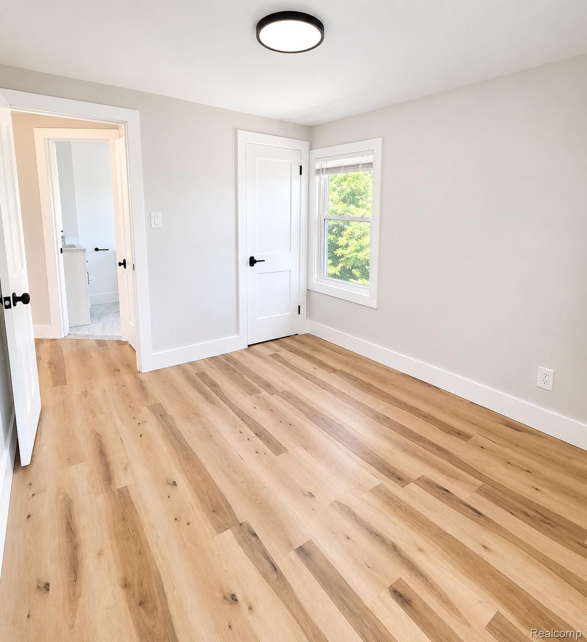 20024 Meyers Road Detroit, MI 48235 - Photo 9 of 16 Room featuring wood-finish flooring, white baseboards, and a contemporary ceiling light fixture