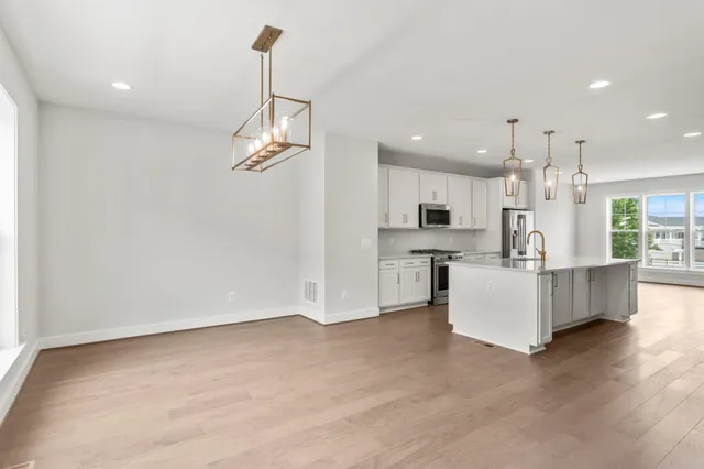 a view of kitchen with kitchen island white cabinets and refrigerator