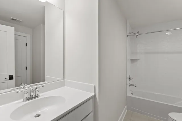 an empty room with windows and ceiling fan