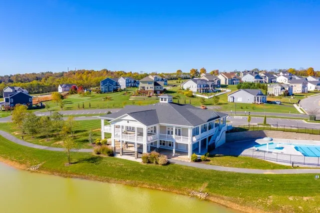 an aerial view of residential houses with outdoor space and trees