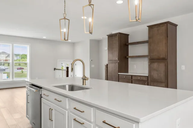a kitchen with stainless steel appliances a sink a refrigerator and a counter space