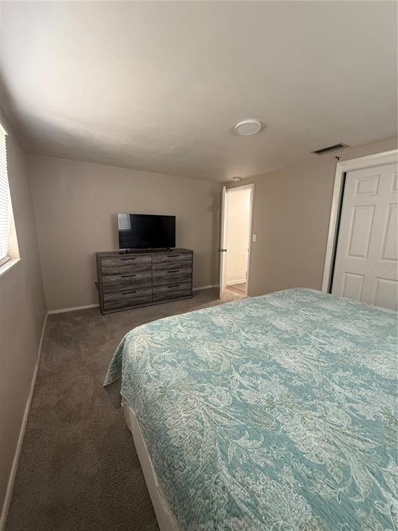 3625 Windham Drive Holiday, FL 34691 - Photo 19 of 28 a spacious bedroom with a bed and a flat screen tv