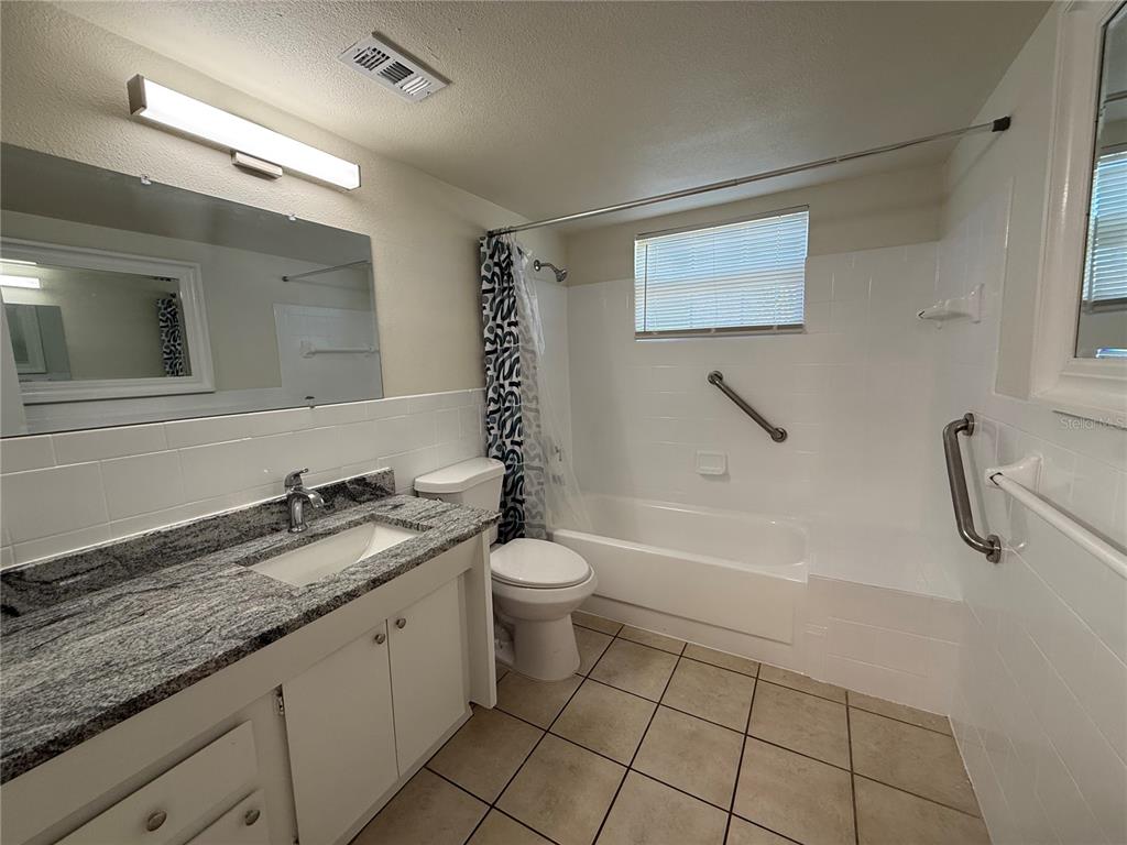 3625 Windham Drive Holiday, FL 34691 - Photo 25 of 28 a bathroom with a granite countertop sink a toilet and bathtub