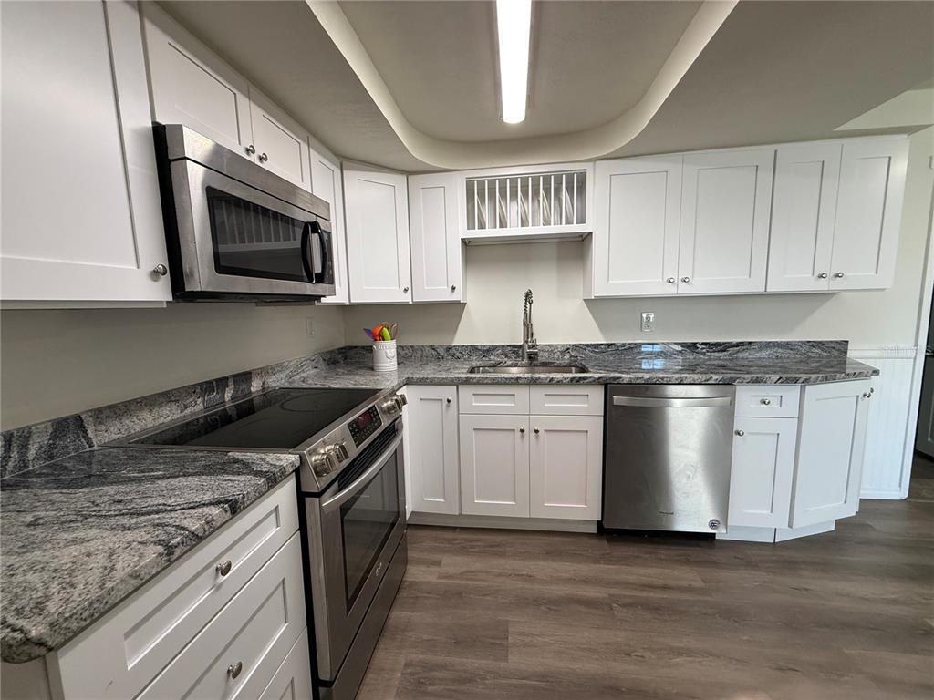 3625 Windham Drive Holiday, FL 34691 - Photo 3 of 28 a kitchen with stainless steel appliances granite countertop a sink and a stove