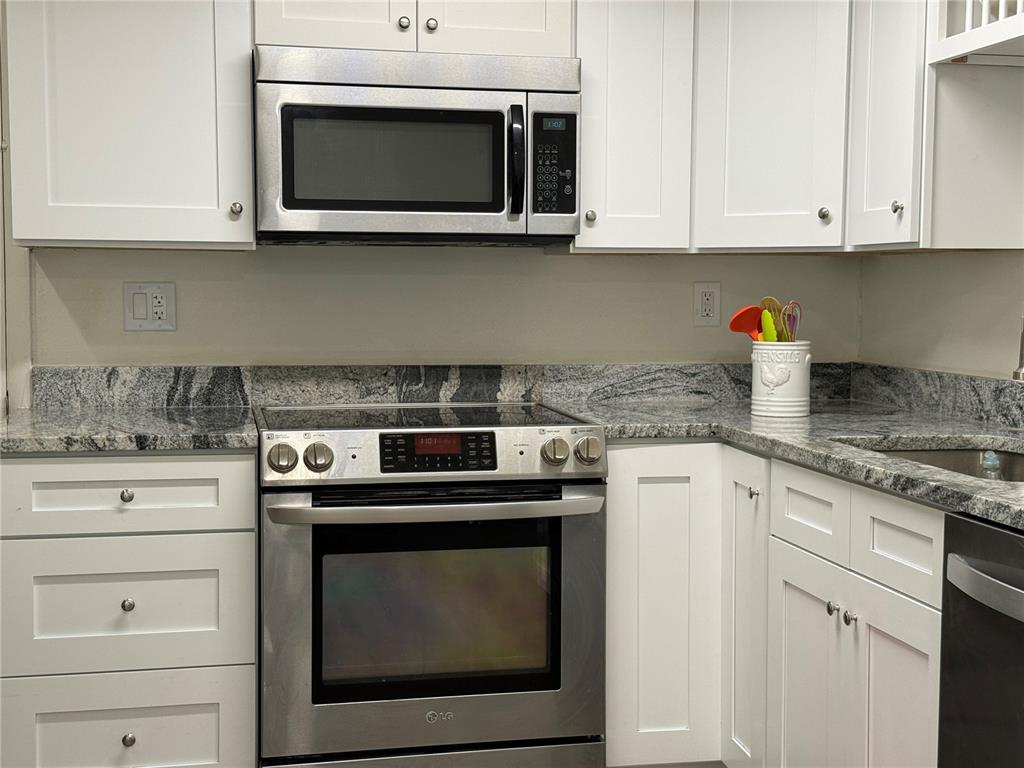 3625 Windham Drive Holiday, FL 34691 - Photo 4 of 28 a kitchen with stainless steel appliances granite countertop white cabinets a stove a sink and dishwasher
