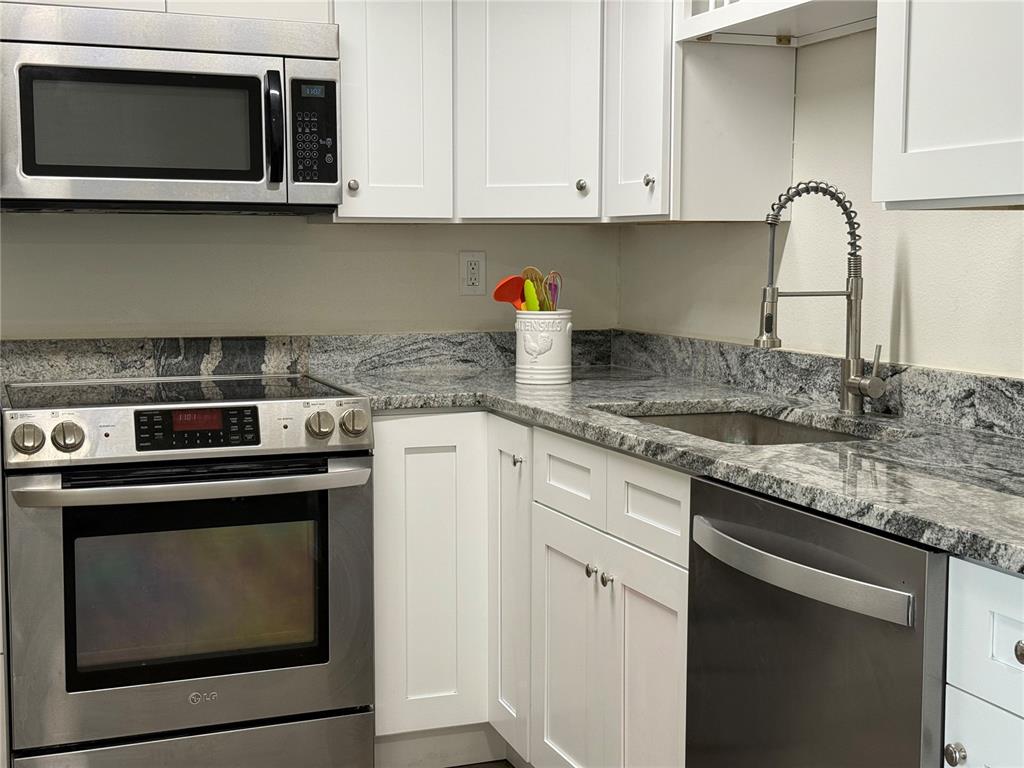 3625 Windham Drive Holiday, FL 34691 - Photo 6 of 28 a kitchen with stainless steel appliances granite countertop a stove microwave and sink