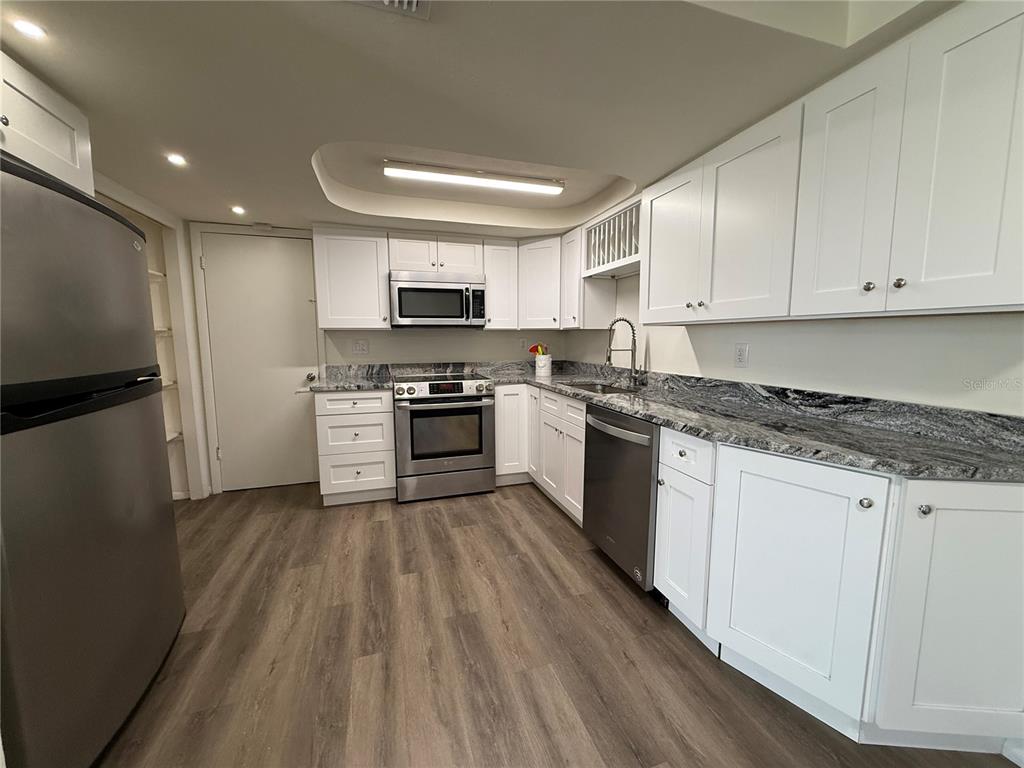 3625 Windham Drive Holiday, FL 34691 - Photo 10 of 28 a kitchen with kitchen island granite countertop stainless steel appliances and view living room