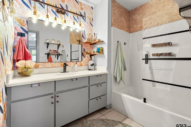 a bathroom with a tub sink and mirror