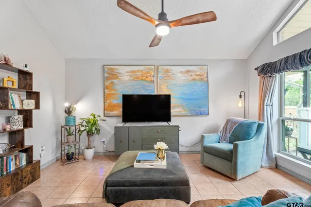 a living room with furniture a flat screen tv and a large window