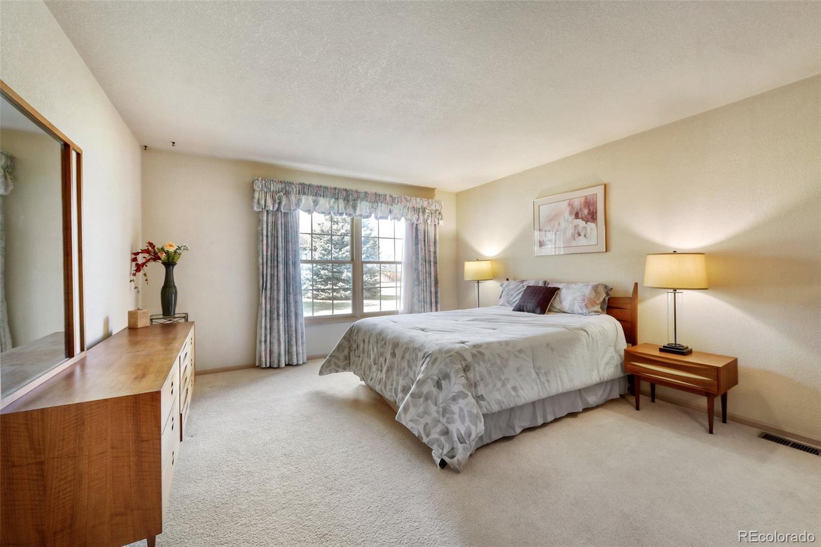 4823 Greenwich Place Highlands Ranch, CO 80130 - Photo 19 of 28 a spacious bedroom with a bed and a couch