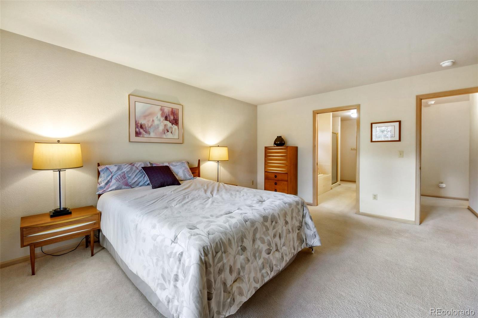 4823 Greenwich Place Highlands Ranch, CO 80130 - Photo 20 of 28 a spacious bedroom with a bed and a lamp