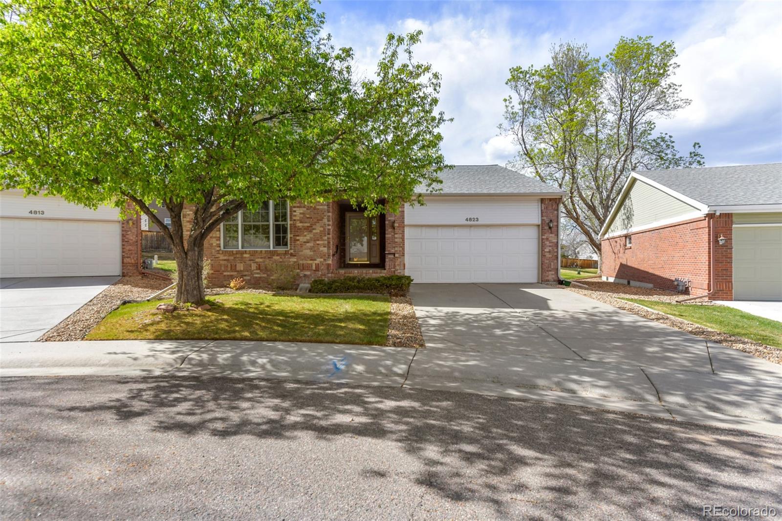 4823 Greenwich Place Highlands Ranch, CO 80130 - Photo 2 of 28 a view of a house with large trees and plants