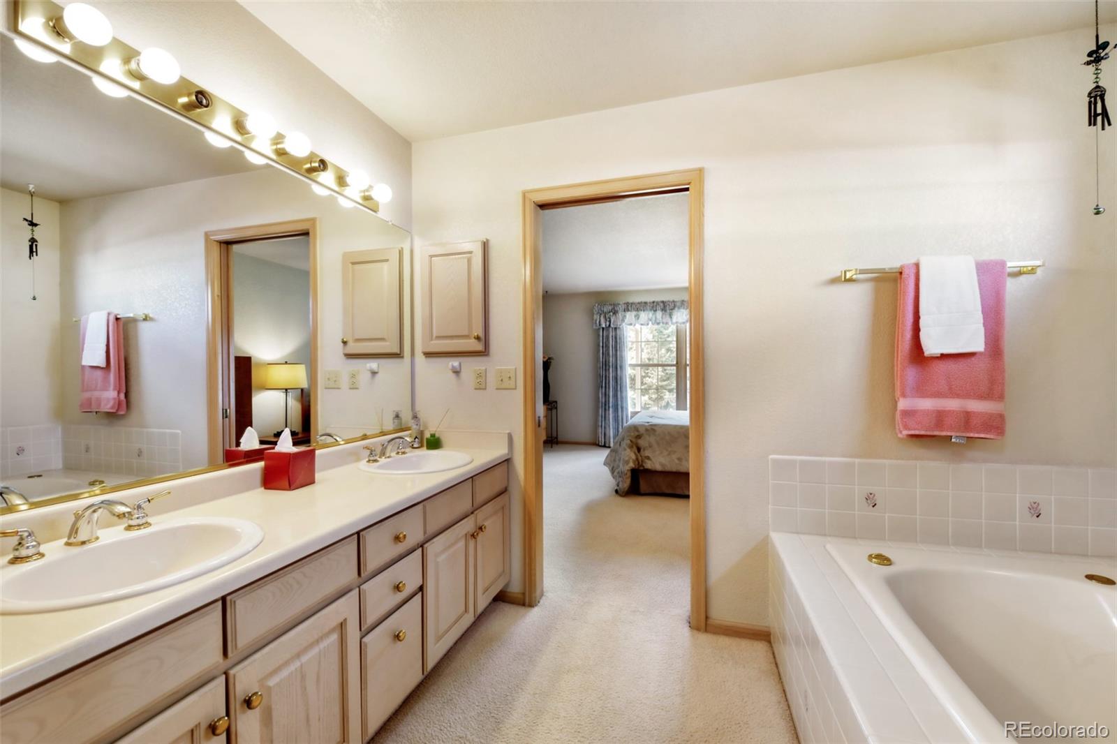 4823 Greenwich Place Highlands Ranch, CO 80130 - Photo 22 of 28 a spacious bathroom with a double vanity sink mirror and bathtub
