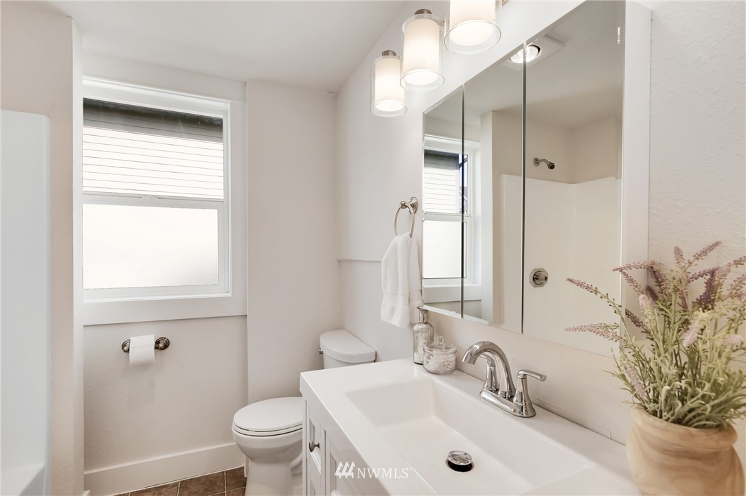 162 18th Avenue Seattle, WA 98122 - Photo 22 of 38 a bathroom with a sink a toilet and a mirror