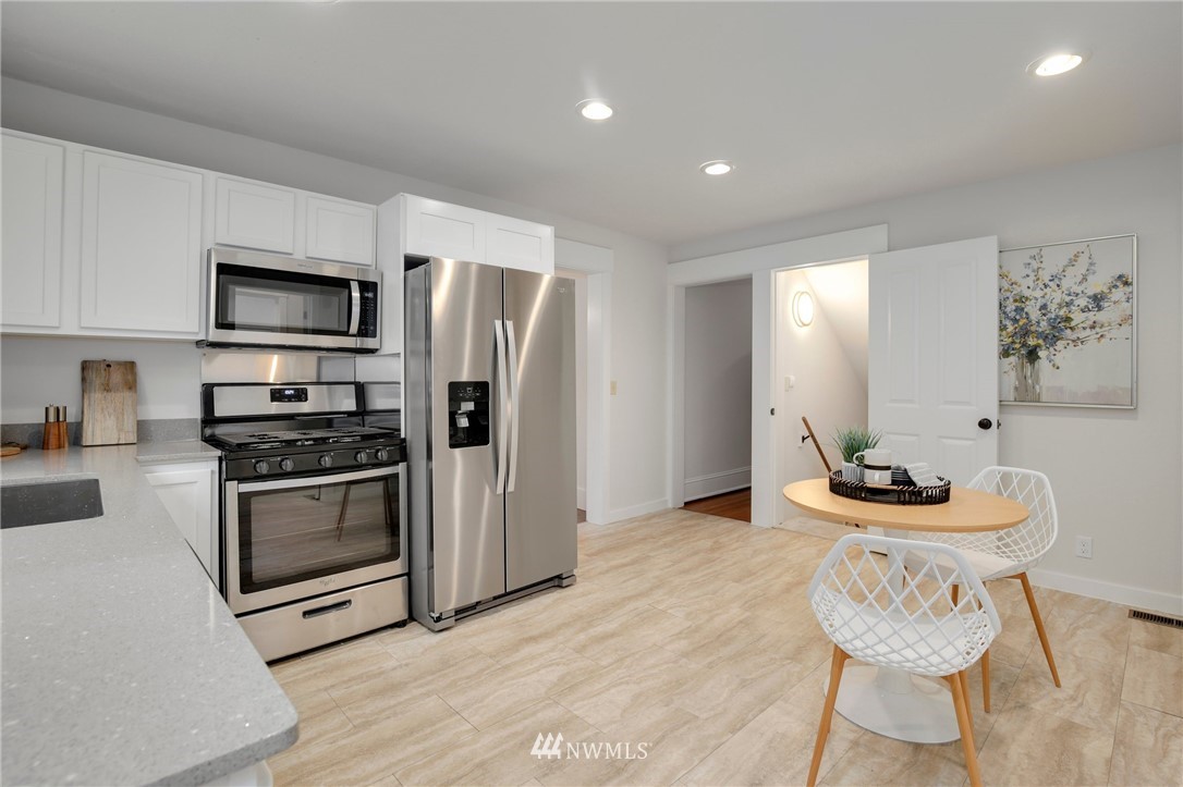 162 18th Avenue Seattle, WA 98122 - Photo 25 of 38 a kitchen with stainless steel appliances kitchen island granite countertop a stove a sink and a refrigerator