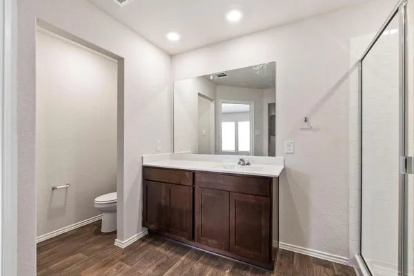 a bathroom with a sink and mirror with toilet