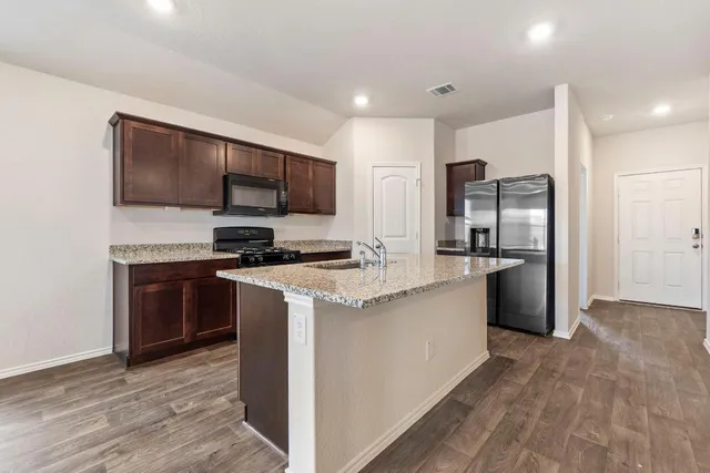 a kitchen with stainless steel appliances a stove a refrigerator and a sink