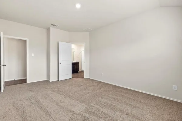 a view of an empty room with closet and a window