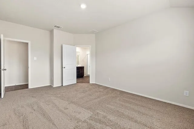 a view of an empty room with closet and a window
