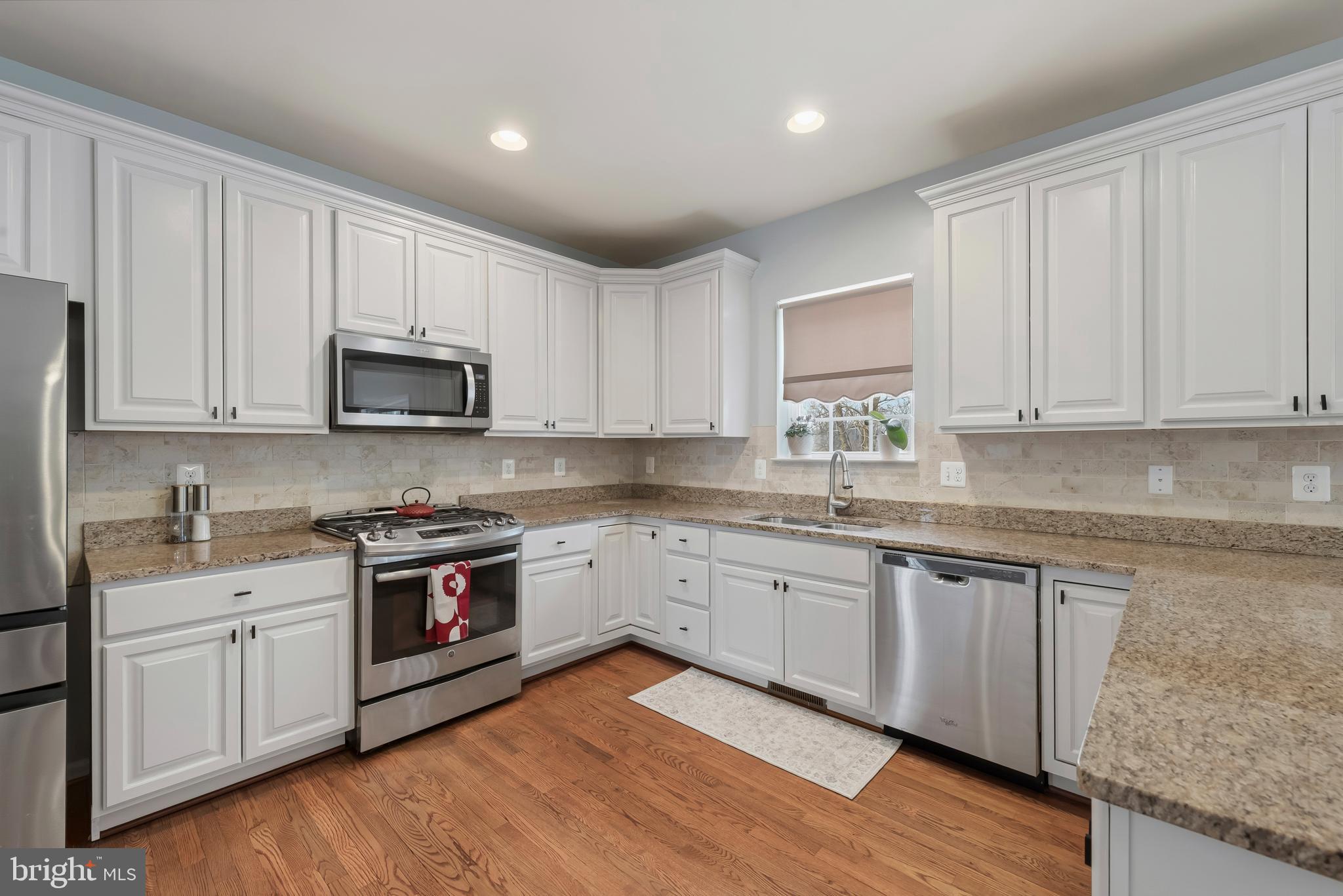 3007 Bender Ridge Court Baltimore, MD 21234 - Photo 8 of 39 a kitchen with stainless steel appliances granite countertop white cabinets sink and stove