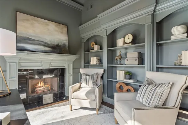 a living room with furniture a fireplace and a large window
