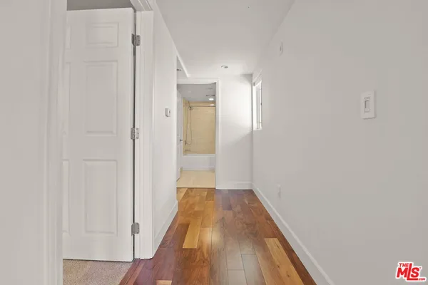 a view of a hallway with wooden floor