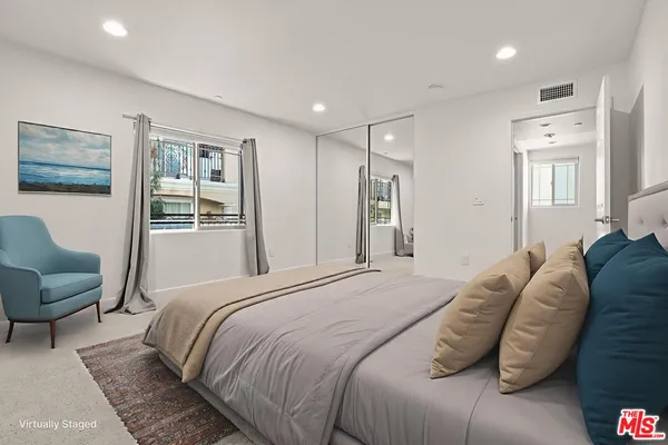 a bedroom with a large bed couch and a window