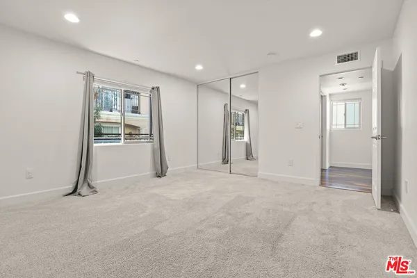 an empty room with closet and mirrors