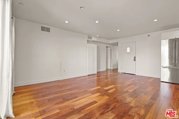 a view of an empty room with wooden floor