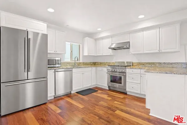 a kitchen with a refrigerator stove top oven and cabinets