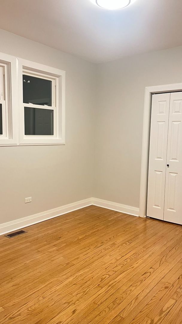 1201 South 15th Avenue Maywood, IL 60153 - Photo 14 of 28 a view of an empty room with wooden floor and a window