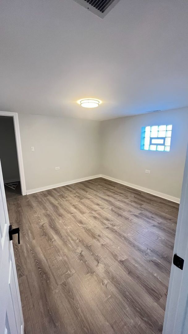 1201 South 15th Avenue Maywood, IL 60153 - Photo 23 of 28 an empty room with wooden floor and windows