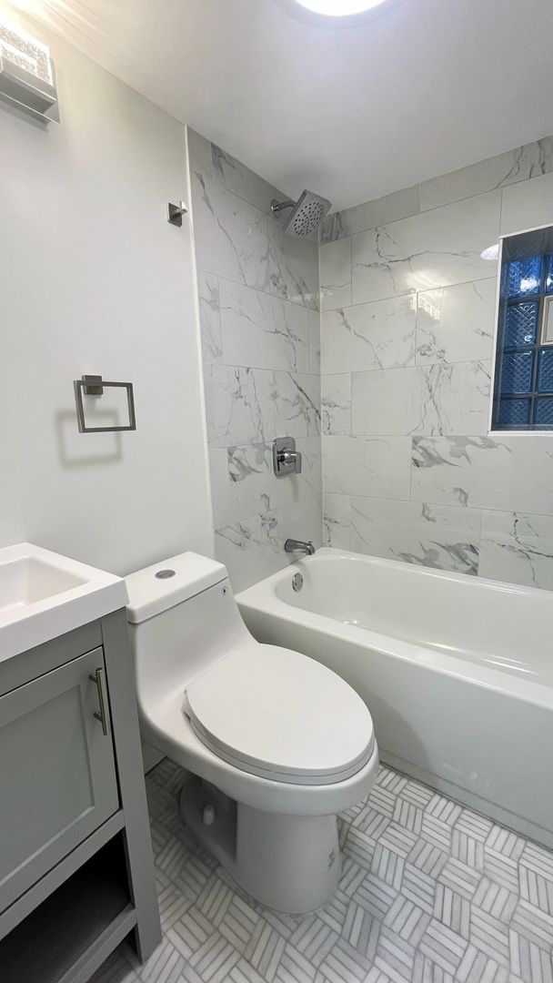 1201 South 15th Avenue Maywood, IL 60153 - Photo 25 of 28 a white toilet and tub sitting next to a bathroom sink