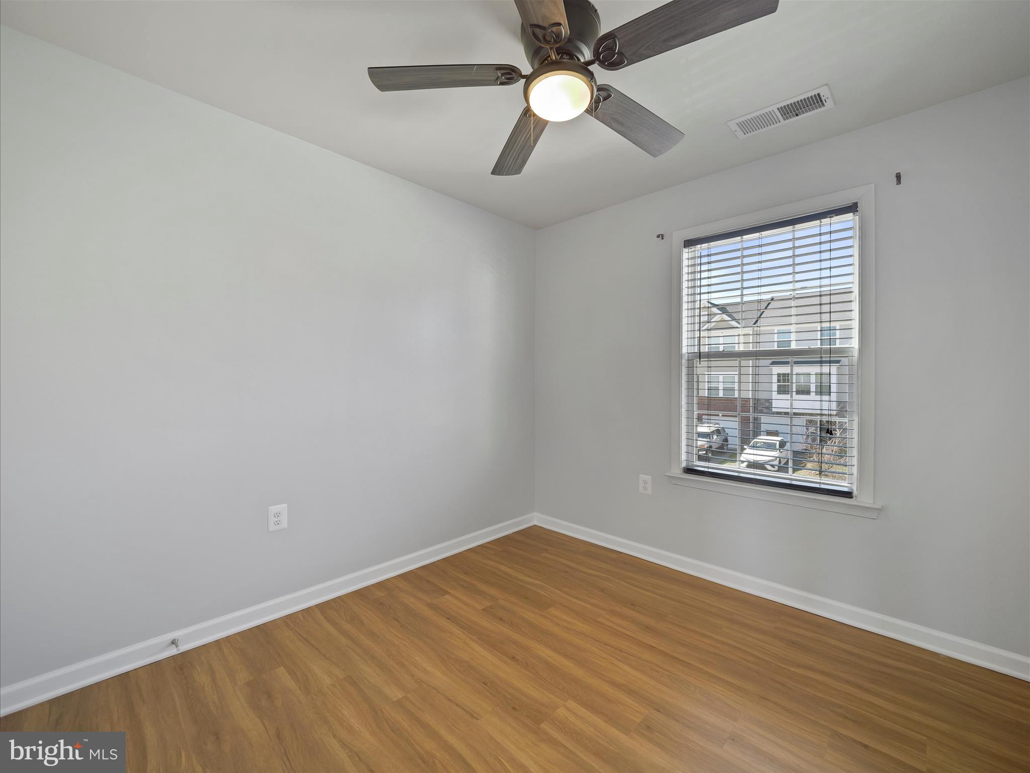 1142 Stallion Street Ranson, WV 25438 - Photo 27 of 31 an empty room with wooden floor fan and windows