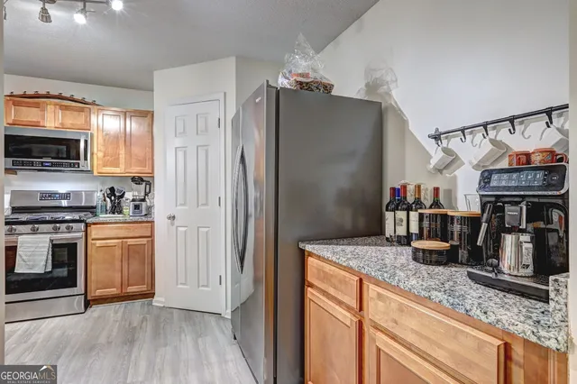 a kitchen with stainless steel appliances granite countertop a refrigerator and a sink