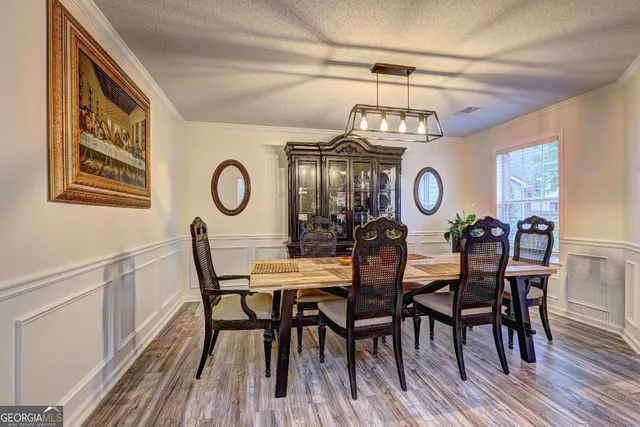 a view of a dining room and livingroom with furniture wooden floor and a clock