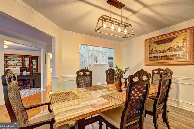 a view of a dining room with furniture a chandelier and wooden floor