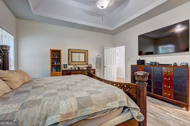 a bedroom with a bed and a flat tv screen on wall