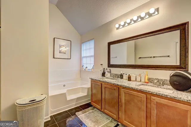 a bathroom with a granite countertop sink mirror vanity and toilet