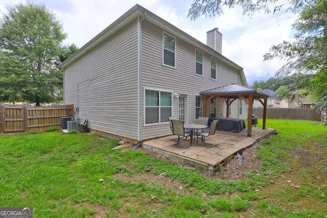 a view of a house with backyard and sitting area