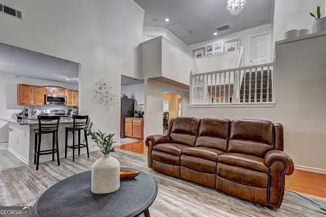 a living room with furniture kitchen view and a window