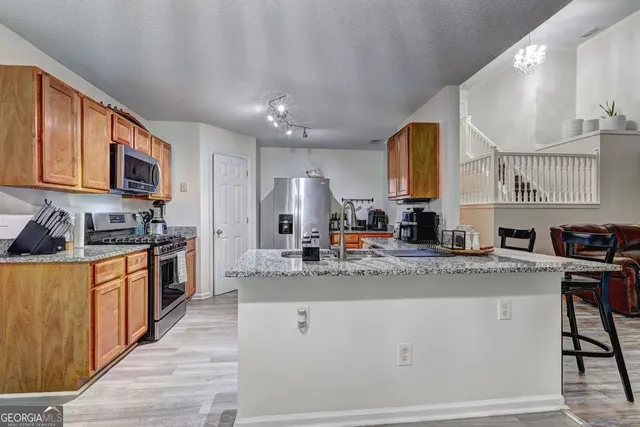 a kitchen with stainless steel appliances granite countertop a sink stove and cabinets
