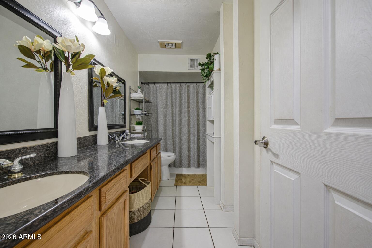 3107 West Montebello Avenue Phoenix, AZ 85017 - Photo 19 of 30 a spacious bathroom with a granite countertop sink a mirror and a shower