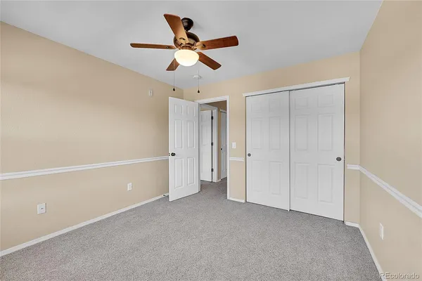 a view of a livingroom with a ceiling fan & window