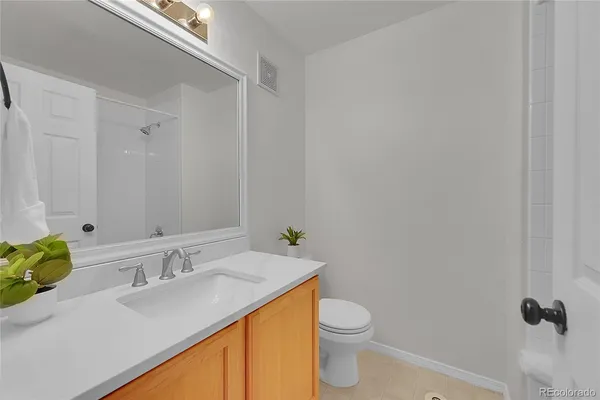 a bathroom with a granite countertop sink a toilet and a mirror