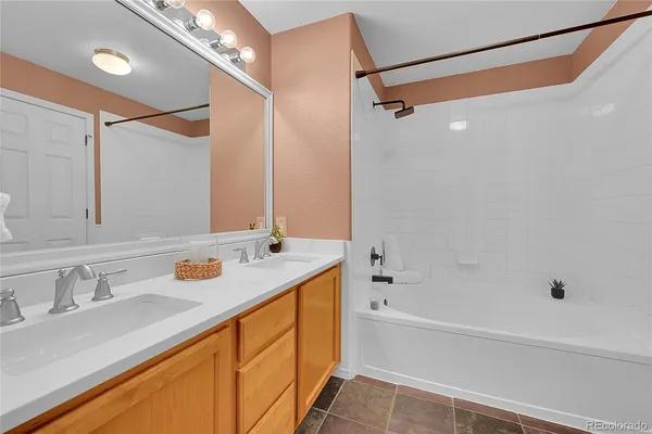 a bathroom with a granite countertop sink mirror vanity and bathtub