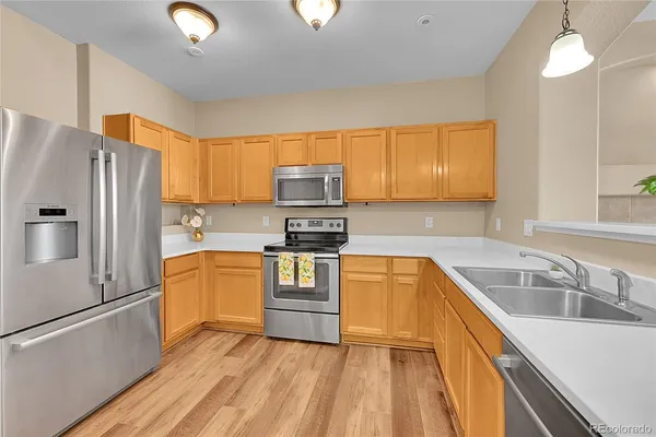 a kitchen with granite countertop a refrigerator stove and sink